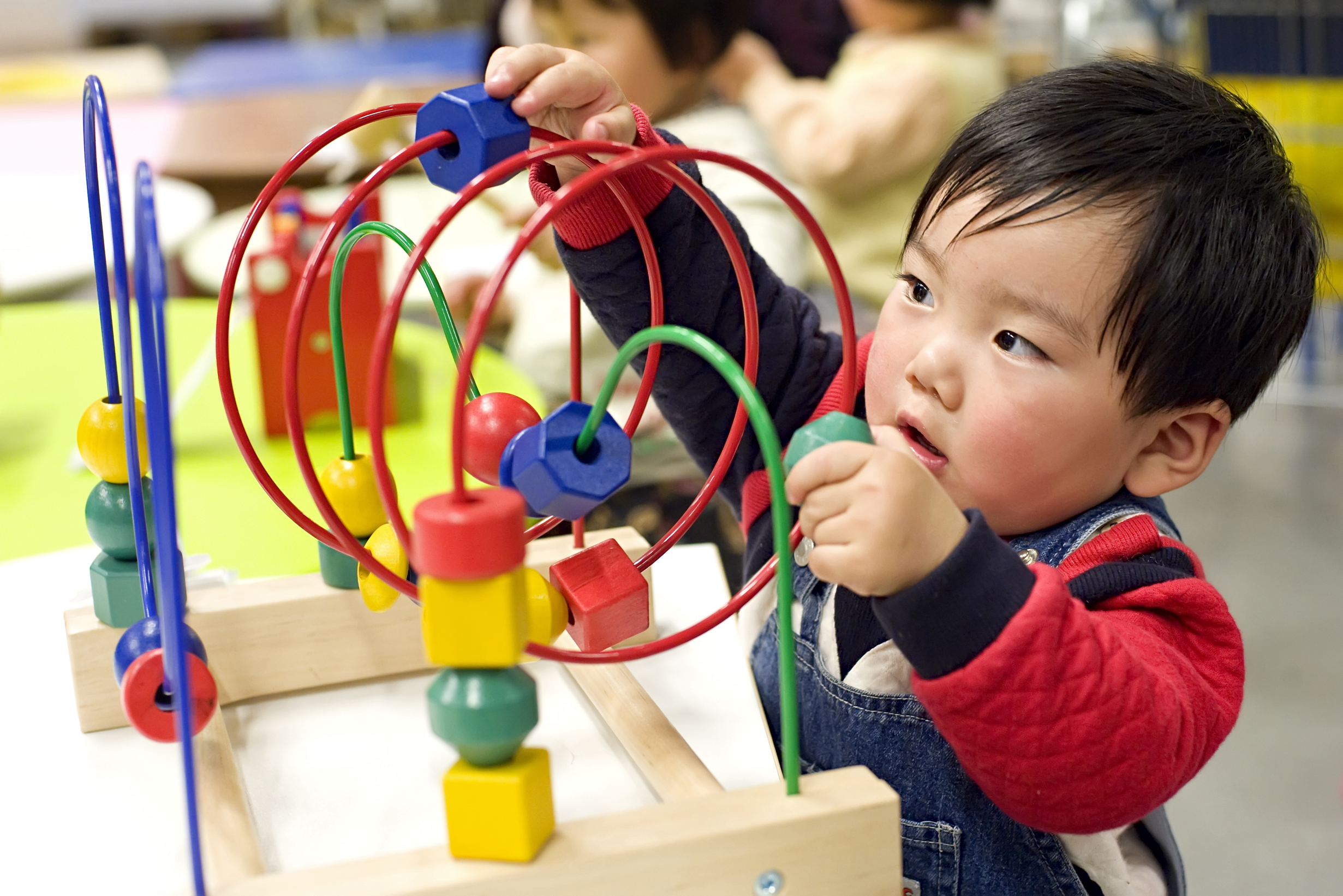 Baby playing with toy, focussed.